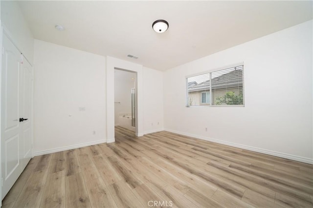 8063 Cambria Cir, Stanton, CA 90680 - unfurnished bedroom with light wood-type flooring, baseboards, and connected bathroom