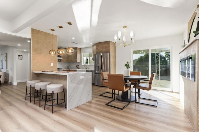 6802 Maury Dr, San Diego, CA 92119 - kitchen featuring stainless steel fridge, a chandelier, modern cabinets, a breakfast bar area, and a peninsula