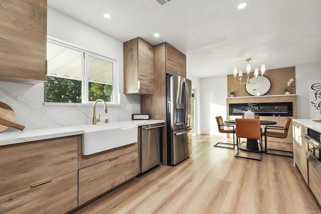 6802 Maury Dr, San Diego, CA 92119 - kitchen with appliances with stainless steel finishes, a sink, backsplash, light wood-type flooring, and modern cabinets