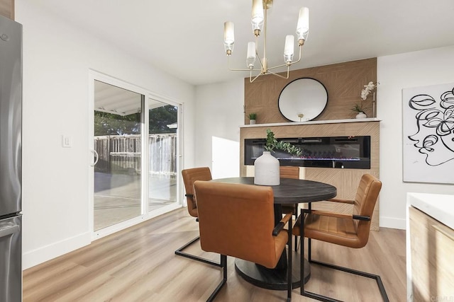 6802 Maury Dr, San Diego, CA 92119 - dining room with a glass covered fireplace, wood finished floors, baseboards, and a chandelier