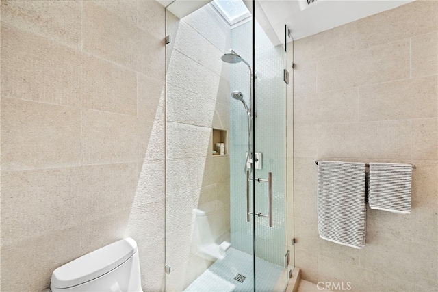 full bath featuring tile walls, a shower stall, and toilet