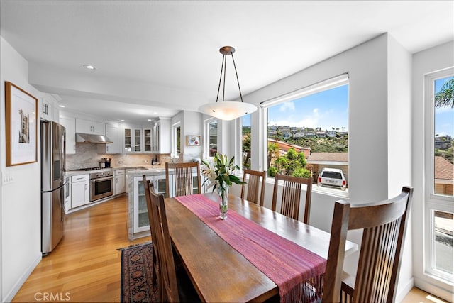 dining room featuring light wood-style flooring, recessed lighting, and wine cooler