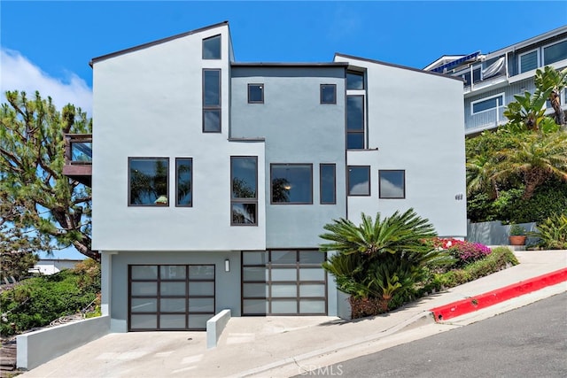 683 Alta Vista Way, Laguna Beach, CA 92651 - contemporary home featuring stucco siding, an attached garage, and driveway