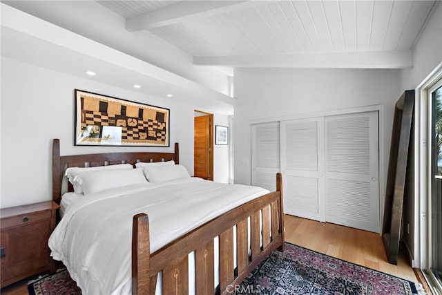 bedroom featuring beamed ceiling, light wood-type flooring, recessed lighting, wooden ceiling, and a closet