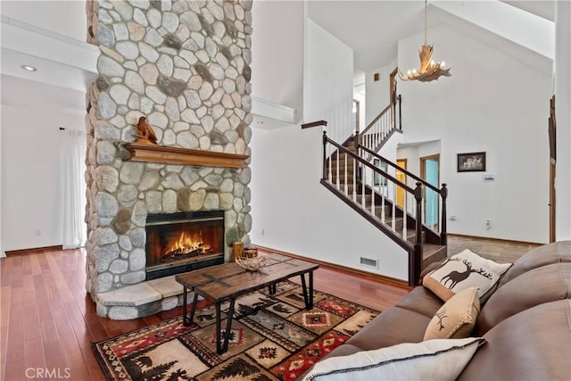 26061 Augusta Dr, Lake Arrowhead, CA 92391 - living area featuring high vaulted ceiling, baseboards, a fireplace, a chandelier, and wood finished floors