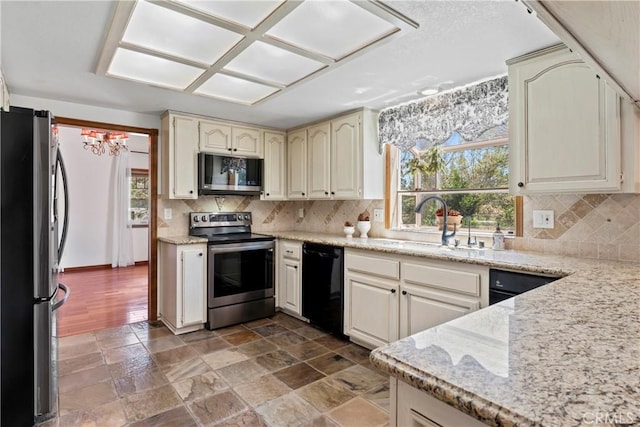 26061 Augusta Dr, Lake Arrowhead, CA 92391 - kitchen featuring appliances with stainless steel finishes, cream cabinets, a sink, decorative backsplash, and light stone countertops