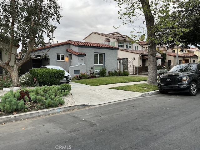 4183 4th Ave, Los Angeles, CA 90008 - mediterranean / spanish-style home featuring stucco siding, a tile roof, and a front lawn