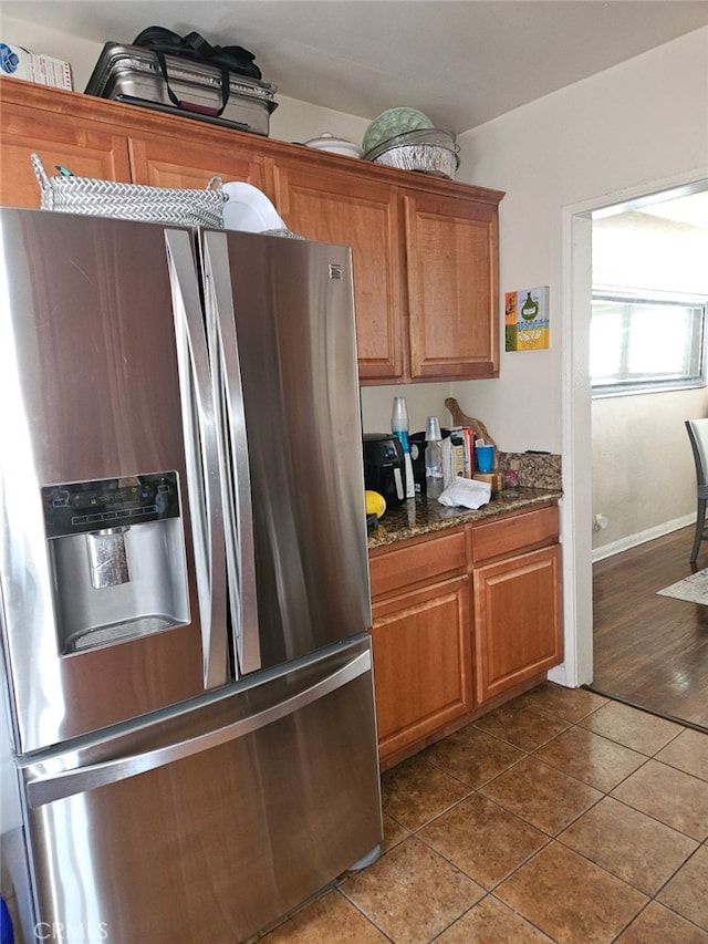 4183 4th Ave, Los Angeles, CA 90008 - kitchen with stainless steel refrigerator with ice dispenser, brown cabinets, and dark tile patterned flooring