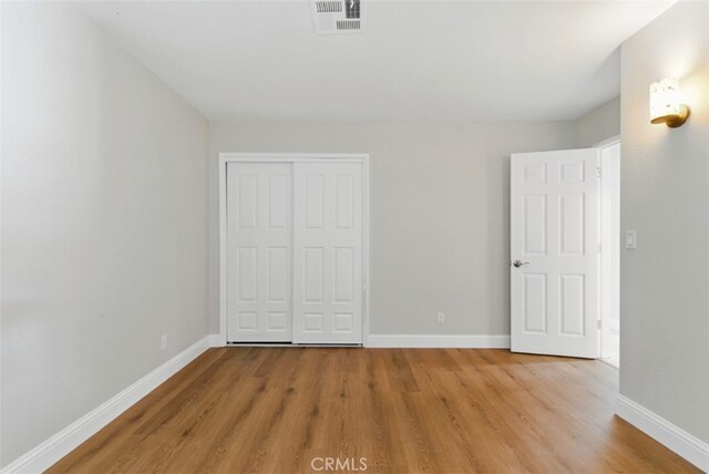 56620 Hidden Gold Dr, Yucca Valley, CA 92284 - unfurnished bedroom featuring light wood-style floors, baseboards, and a closet