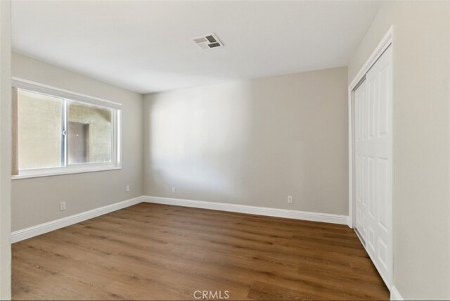 56620 Hidden Gold Dr, Yucca Valley, CA 92284 - unfurnished bedroom featuring wood finished floors, a closet, and baseboards