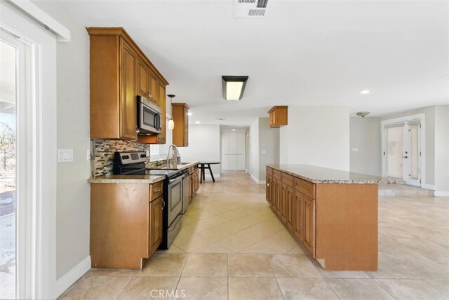 56620 Hidden Gold Dr, Yucca Valley, CA 92284 - kitchen with stainless steel appliances, brown cabinets, baseboards, tasteful backsplash, and recessed lighting