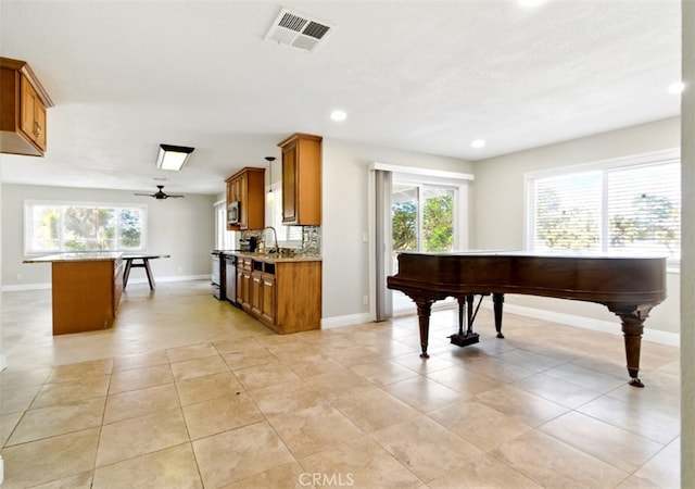 56620 Hidden Gold Dr, Yucca Valley, CA 92284 - kitchen featuring brown cabinets, plenty of natural light, baseboards, a sink, and recessed lighting