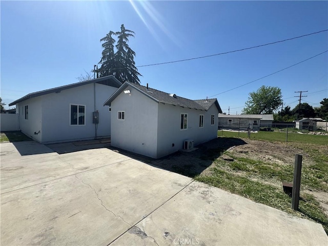 rear view of house with a patio area, fence, stucco siding, and cooling unit