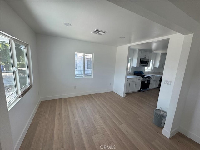 unfurnished living room with light wood-style floors and baseboards
