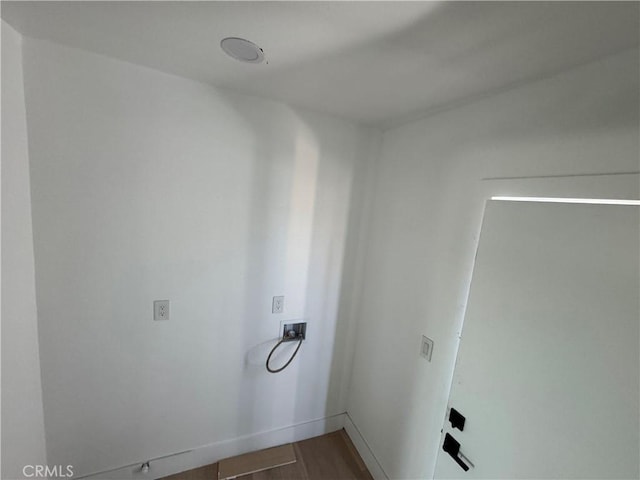 clothes washing area featuring washer hookup, wood finished floors, and baseboards