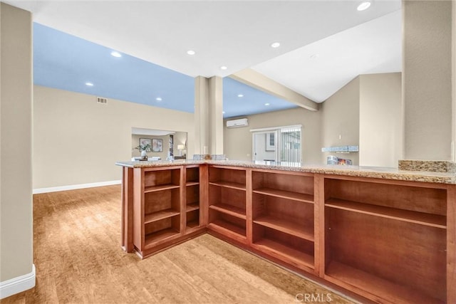 15605 Facilidad St, Hacienda Heights, CA 91745 - kitchen with open shelves, a wall unit AC, light wood-style flooring, baseboards, and light stone counters
