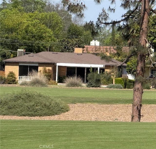 4333 N Country Club Ln, Long Beach, CA 90807 - view of front of house featuring a front yard, a chimney, a shingled roof, and brick siding