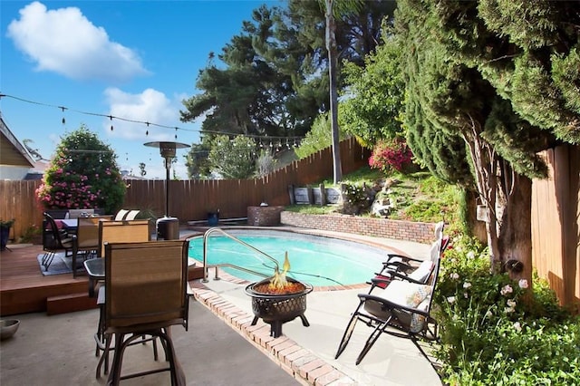 7391 Margerum Ave, San Diego, CA 92120 - view of pool featuring a fire pit, a fenced backyard, outdoor dining space, a patio, and a wooden deck