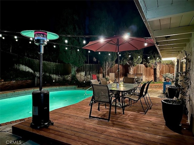 7391 Margerum Ave, San Diego, CA 92120 - pool at twilight featuring a fenced backyard, outdoor dining space, and a deck