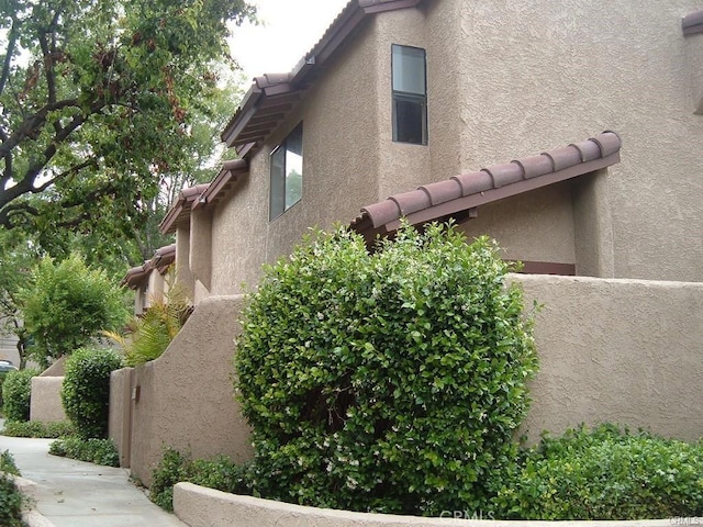 2452 Chandler Ave Unit 1, Simi Valley, CA 93065 - view of side of home with stucco siding, fence, and a tiled roof