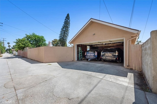 detached garage featuring fence