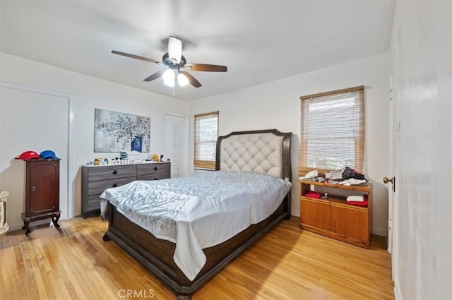 bedroom featuring light wood finished floors, ceiling fan, and baseboards