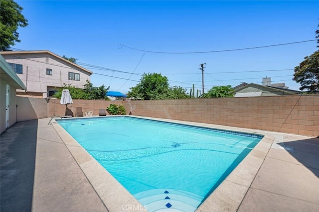 view of swimming pool featuring a fenced backyard and a patio area