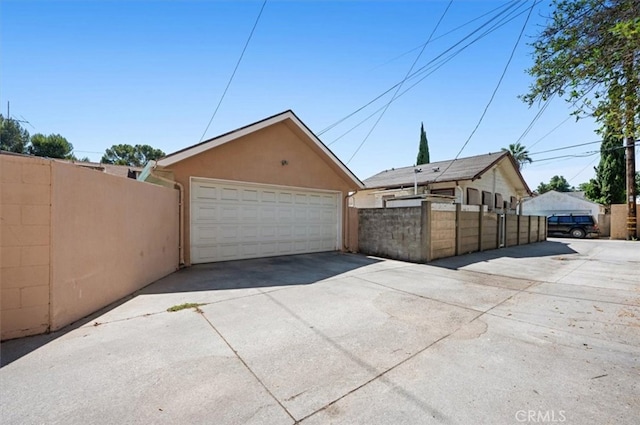 detached garage featuring fence