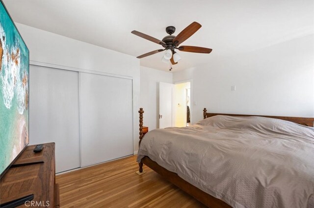 bedroom with wood finished floors, a closet, and a ceiling fan
