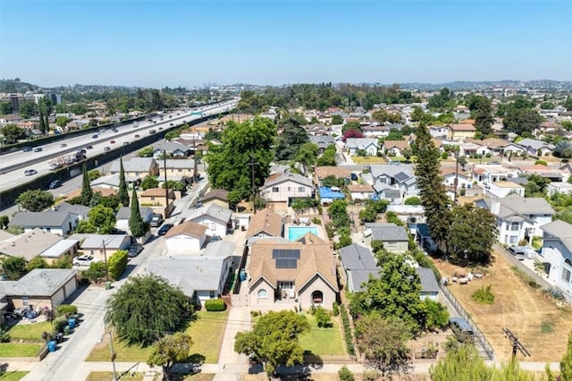 aerial view of property and surrounding area featuring nearby suburban area