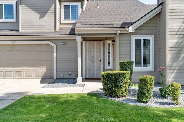 doorway to property with concrete driveway, an attached garage, and a shingled roof