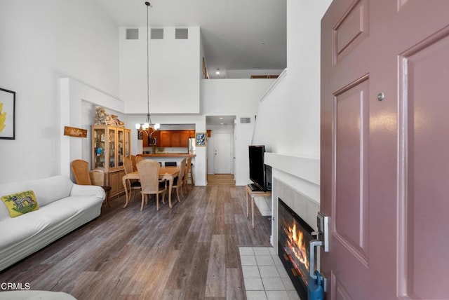 1219 Lost Point Ln, Oxnard, CA 93030 - living area with a high ceiling, a chandelier, wood finished floors, and a tile fireplace