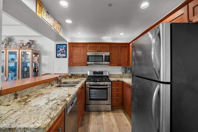 1219 Lost Point Ln, Oxnard, CA 93030 - kitchen with appliances with stainless steel finishes, a sink, light wood-style floors, brown cabinetry, and recessed lighting
