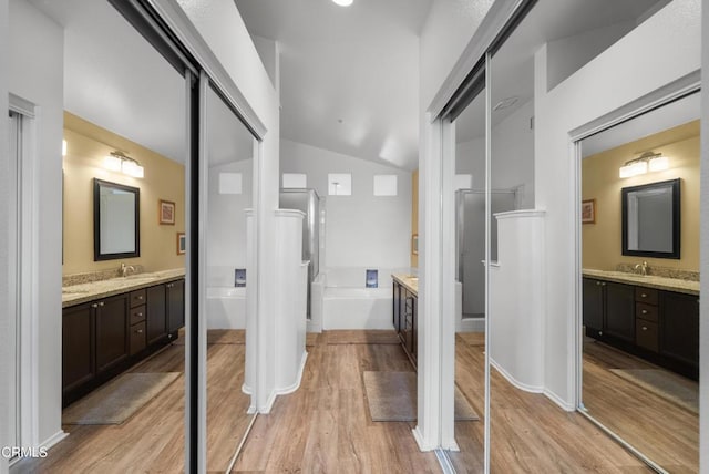 1219 Lost Point Ln, Oxnard, CA 93030 - full bathroom featuring wood finished floors, a garden tub, two vanities, and vaulted ceiling
