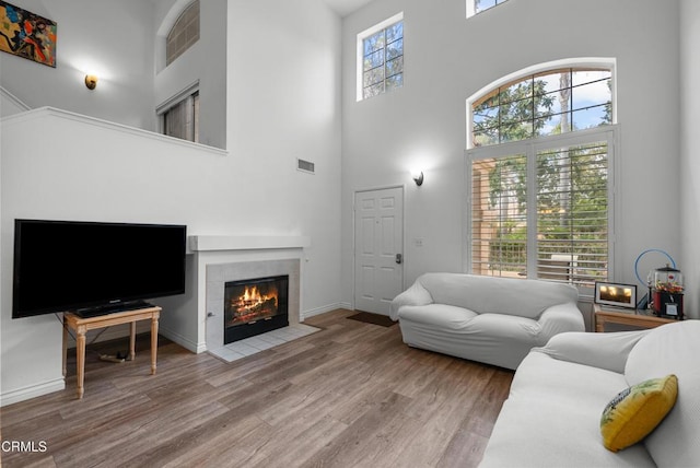 1219 Lost Point Ln, Oxnard, CA 93030 - living room with a towering ceiling, wood finished floors, a tile fireplace, and baseboards