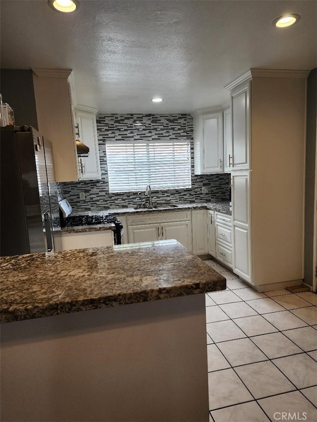 1009 Walnut St, Inglewood, CA 90301 - kitchen with a sink, range with gas cooktop, freestanding refrigerator, decorative backsplash, and white cabinetry