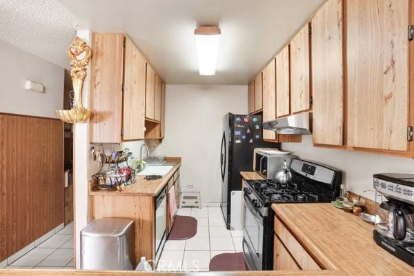 3805 Eisenhower Dr, Lake Elsinore, CA 92530 - kitchen featuring stainless steel appliances, under cabinet range hood, light brown cabinetry, light countertops, and light tile patterned floors