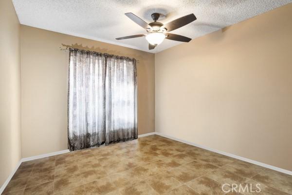 3805 Eisenhower Dr, Lake Elsinore, CA 92530 - unfurnished room with a ceiling fan, a textured ceiling, and baseboards