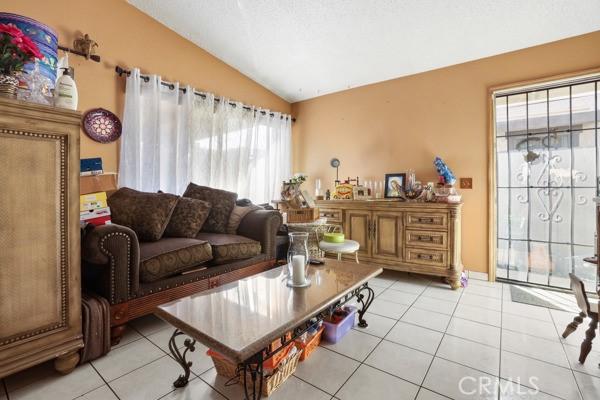3805 Eisenhower Dr, Lake Elsinore, CA 92530 - living room featuring lofted ceiling and light tile patterned floors