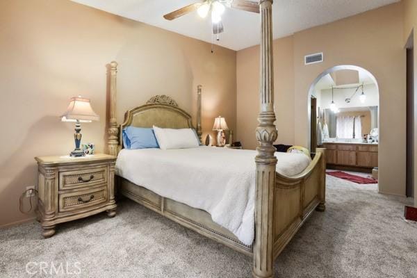 3805 Eisenhower Dr, Lake Elsinore, CA 92530 - carpeted bedroom with arched walkways, ensuite bathroom, and ceiling fan