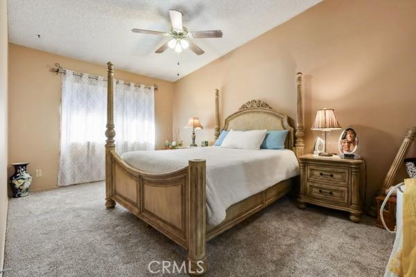 3805 Eisenhower Dr, Lake Elsinore, CA 92530 - carpeted bedroom with a ceiling fan and vaulted ceiling