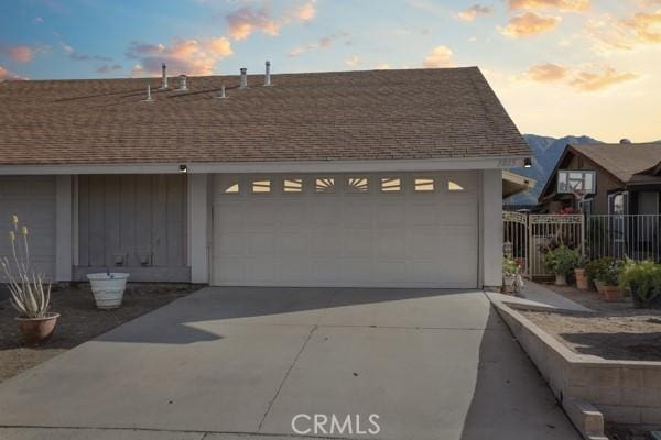 3805 Eisenhower Dr, Lake Elsinore, CA 92530 - view of front of property featuring fence, concrete driveway, a garage, and a shingled roof
