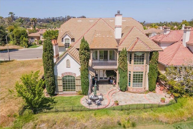 16056 Avenida Calma, Rancho Santa Fe, CA 92091 - tudor house featuring a balcony, stucco siding, a tile roof, a chimney, and a patio