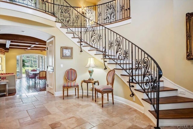 16056 Avenida Calma, Rancho Santa Fe, CA 92091 - staircase featuring stone tile flooring, beam ceiling, and a towering ceiling