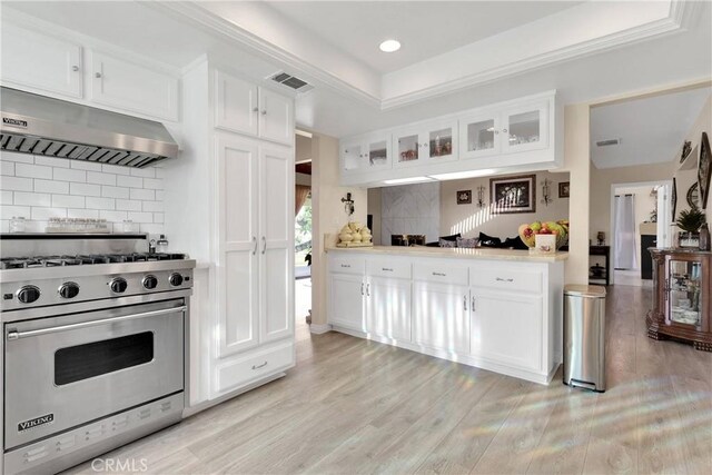 18060 Pebble Beach Dr, Victorville, CA 92395 - kitchen featuring premium range, under cabinet range hood, backsplash, glass insert cabinets, and white cabinetry