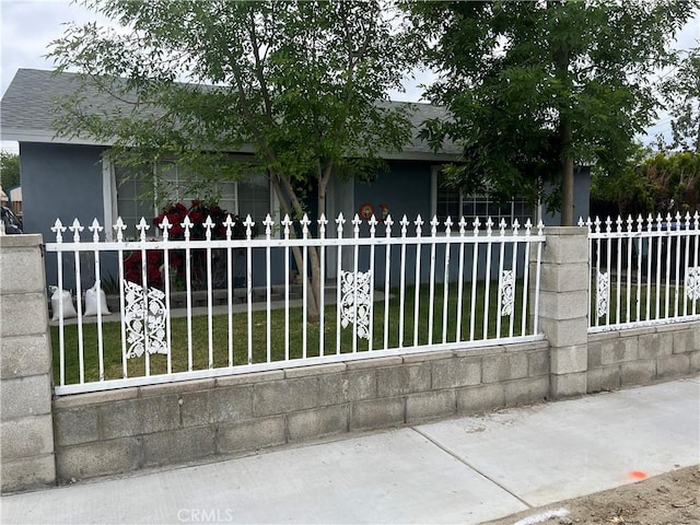 615 S Hewitt St, San Jacinto, CA 92583 - obstructed view of property featuring a fenced front yard, stucco siding, and a shingled roof
