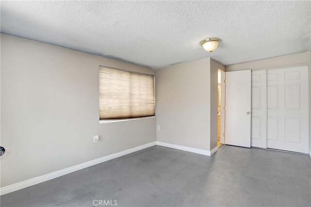 615 S Hewitt St, San Jacinto, CA 92583 - unfurnished bedroom featuring a textured ceiling, a closet, and concrete floors