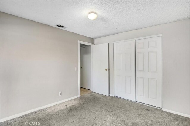 615 S Hewitt St, San Jacinto, CA 92583 - unfurnished bedroom featuring carpet floors, a closet, and a textured ceiling
