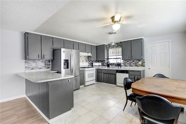 615 S Hewitt St, San Jacinto, CA 92583 - kitchen featuring white appliances, under cabinet range hood, a peninsula, ceiling fan, and light countertops