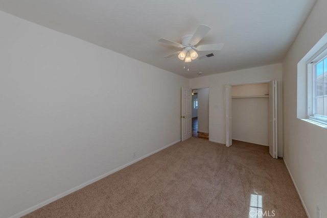 unfurnished bedroom featuring light carpet, a ceiling fan, and baseboards